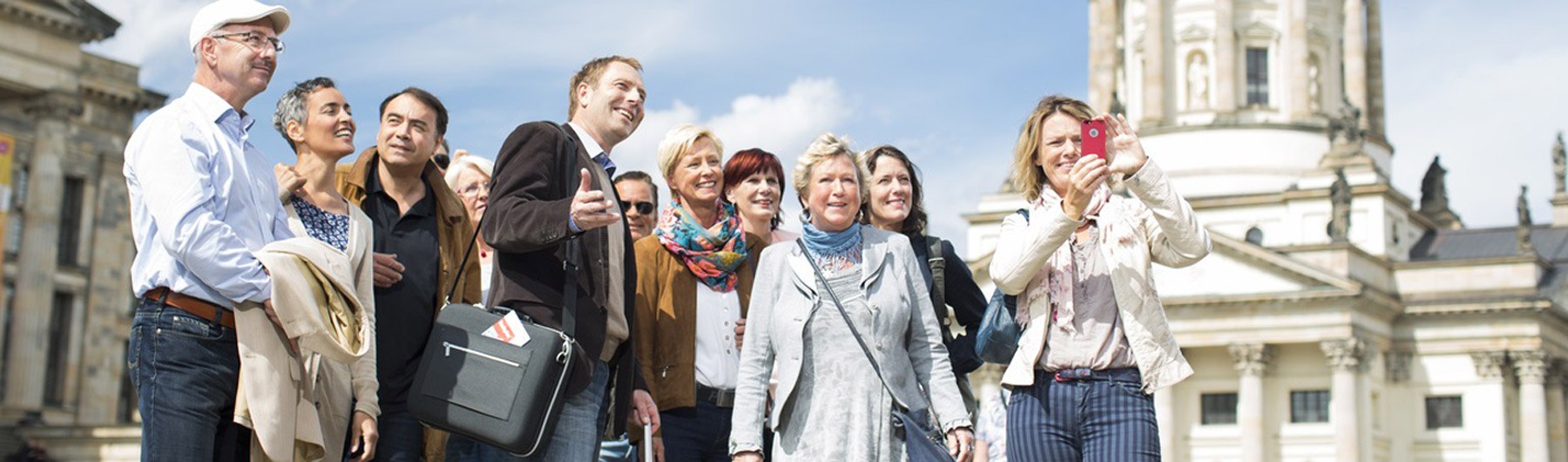 Eine große Gruppe mit Tourguide beim Sightseeing. - BAHNHIT.DE, © getty 